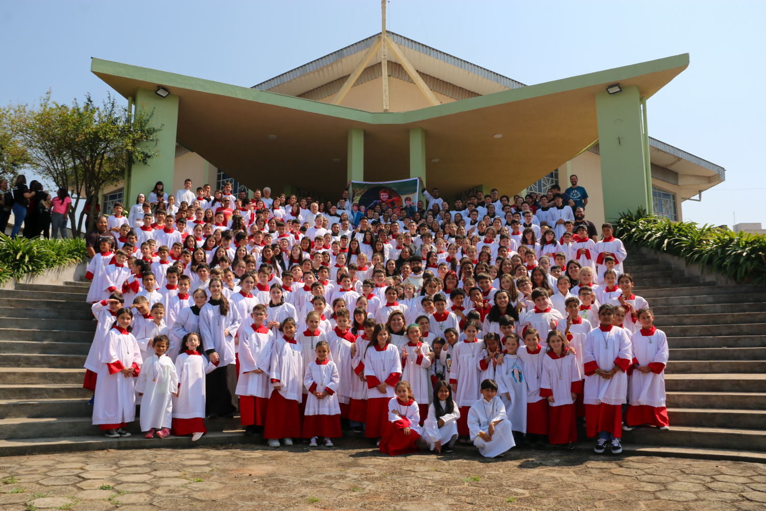 Coroinhas e acólitos reunidos em frente a igreja Nossa Senhora Auxiliadora